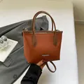 Fashionable orange-brown bucket bag in pebbled leather with top handle and shoulder strap - Brown