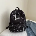 Zwarte schoolrugzak met witte polkadots, strikprints en een modieus labeldecor - Zwart