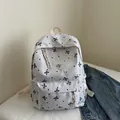 Crèmekleurige canvas rugzak met zwarte strikken, stippenprint en ritsvak aan de voorkant - Wit & Zwart