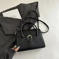 Borsa a mano minimalista in pelle nera con fibbia a ferro di cavallo in argento lucido - Nero