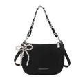 Quilted black shoulder bag with silver chain strap and pearl bow charm on white background - With Pendant / Black