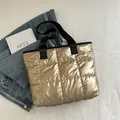 Quilted champagne gold padded tote bag with metallic sheen and black nylon handles - Gold