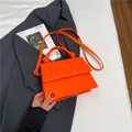 Bright orange structured crossbody bag with knotted handle and matching shoulder strap - Orange