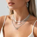 Close-up of layered silver chain set with OT toggle clasp and matching hoop earrings - Silver