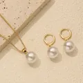 Detailed view of elegant pearl necklace and matching earrings set on stone texture - Gold