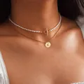 Mehrlagige Goldkette mit K-Buchstaben-Münzanhänger und weißer Perlen-Choker mit OT-Verschluss - Buchstabe K / Gold