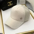 Detail van de ivoorkleurige schaakbordpet met gouden M-logo en ademend mesh aan de achterkant - Verstelbaar / Beige