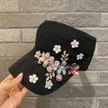 Women's black knitted sun visor hat featuring colorful 3D floral appliques and gold leaf accents - Adult Size (Adjustable) / Black