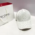 Detailed close-up of sparkling colorful rhinestones on a white stylish baseball cap - White