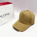 Close-up of khaki baseball cap featuring intricate silver rhinestone embellishments - Brown