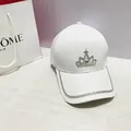 Close-up of white luxury baseball cap featuring rhinestone crown and studded brim detailing - Adult, Adjustable / White