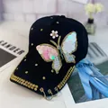 Detalle de gorra de béisbol negra con parche de mariposa de lentejuelas y aros dorados - Adulto, Ajustable / Negro