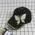 Detail view of a black baseball cap featuring a pearl butterfly and golden rhinestones - Adult Size (Adjustable) / Black