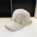 Dettaglio del berretto in pizzo bianco con stampa leopardata oro e catena di cristalli - Taglia Adulto (Regolabile) / Bianco