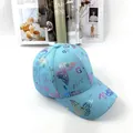 Dettaglio ravvicinato del cappellino azzurro con stampa a farfalla e lettere dorate - Taglia Adulto (Regolabile) / Blu lago