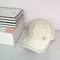 Détail d'une casquette en polaire blanche avec logo M doré orné de strass brillants - 58cm (Ajustable) / Milky blanc