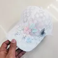 Detalle de gorra de encaje blanco con flores 3D, perlas y bordado de mariposa azul - Talla Adulto (Ajustable) / Blanco (Flor Mariposa)