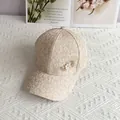 Close-up of beige baseball cap with floral jacquard texture and golden heart jewelry detail - Adult, Adjustable / Beige