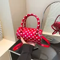 Red boston bag with white polka dots featuring top handles and a detachable shoulder strap - Red