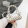 Boston style white barrel bag with black polka dots featuring dual handles and crossbody strap - White