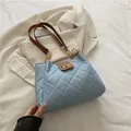 Gewatteerde lichtblauwe draagtas met bruine handvatten en gouden kettingdetails - Blauw