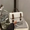 Bolso de hombro de cuero blanco crema retro con asa marrón y correa sobre un espejo - Blanco & Café