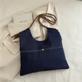 Minimalist deep blue denim tote bag with braided rope strap and gold buckle detail - Dark Blue