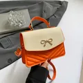 Sac à bandoulière orange avec patchwork de paille et boucle dorée en nœud - Orange