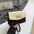 Sac chic en cuir noir et tissage beige avec un nœud doré et motif matelassé élégant - Noir et Blanc