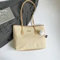 Schicke beige Web-Tragetasche mit braunen Lederriemen und süßem Plüsch-Anhänger - Khaki mit Anhänger