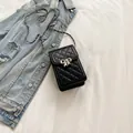 Quilted black leather mini crossbody phone bag with silver bow buckle and chain strap - Black