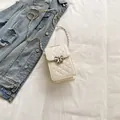 Chic cream quilted mini mobile phone bag with silver bow clasp and chain strap - Off-white