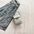 Silver quilted mini phone bag with metal bow clasp and sleek chain strap for women - Silver