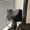 Minimalistische schwarze Schultertasche mit goldener Metallschiene und feinem Riemen - Schwarz