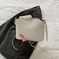 Minimalist white crossbody bag with wavy edge and golden buckle detail for women - White