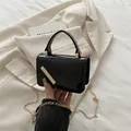 Glanzende zwarte laks lederen crossbody tas met gouden ketting en metalen staafdetail - Zwart
