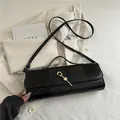 Elegante schwarze Baguette-Tasche mit Krokoprägung, goldfarbenem Schloss und Schultergurt - Schwarz