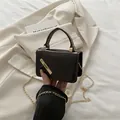 Minimalistische zwarte lakleren crossbody tas met gouden metalen rand en ketting - Bruin
