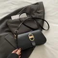 Minimalistische schwarze Leder-Umhängetasche mit strukturierter ovaler Gold-Schnalle - Schwarz