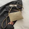 Fashionable beige woven straw crossbody bag with golden hardware and wristlet strap - Khaki
