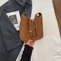 Braune Leder-Schultertasche mit weißen Kontrastnähten und Metallschließe am Riemen - Braun
