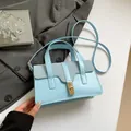Bolso bandolera azul claro en contraste con textura de cuero y hebilla dorada - Azul