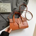Bolso de mano de cuero marrón con solapa tejida y cierre de giro dorado chic - Marrón