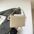 Bolso bandolera blanco crema trenzado con elegante detalle metálico en forma de V - Blanco