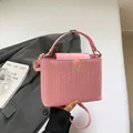 Bolso bandolera rosa con textura tejida, hebilla en V dorada y correa larga - Rosa