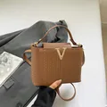 Bolso tote marrón con textura tejida, hebilla en V dorada y correa de hombro a juego - Marrón