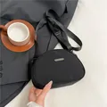 Borsa a tracolla a mezzaluna in nylon nero minimalista con cinturino e placca metallica - Nero
