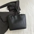 Bolso tote minimalista de cuero negro mate con costuras geométricas y asas delgadas - Negro
