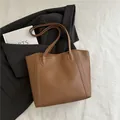 Bolso tote minimalista de cuero sintético marrón con costuras y correas largas al hombro - Marrón