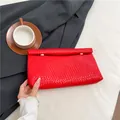 Pochette intrecciata rettangolare rosso vivo con fibbie dorate e texture PU premium - Rosso